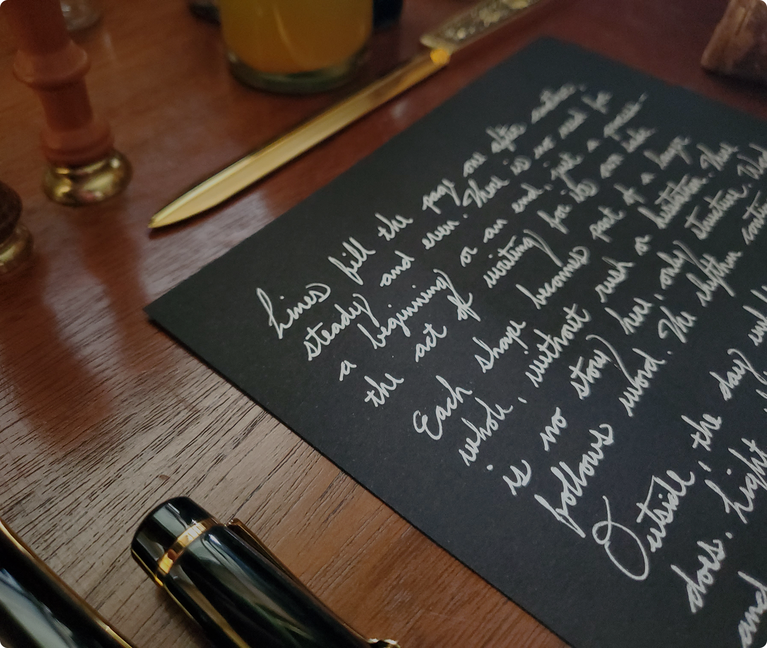 Handwritten intimate letter in cursive silver ink on black paper