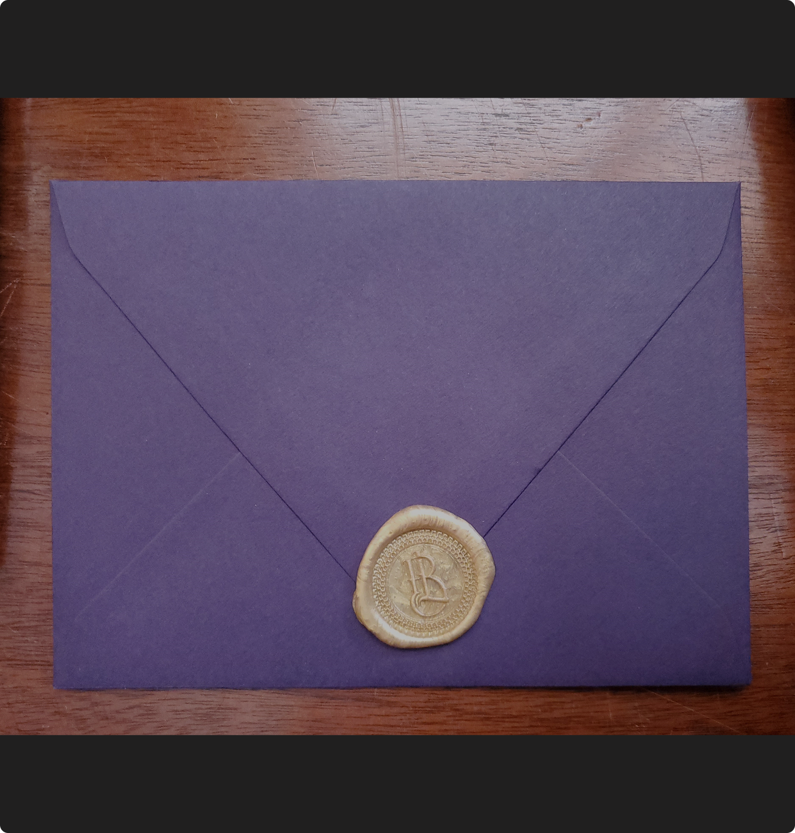 Royal purple envelope with decorative gold wax seal for secret admirer letters