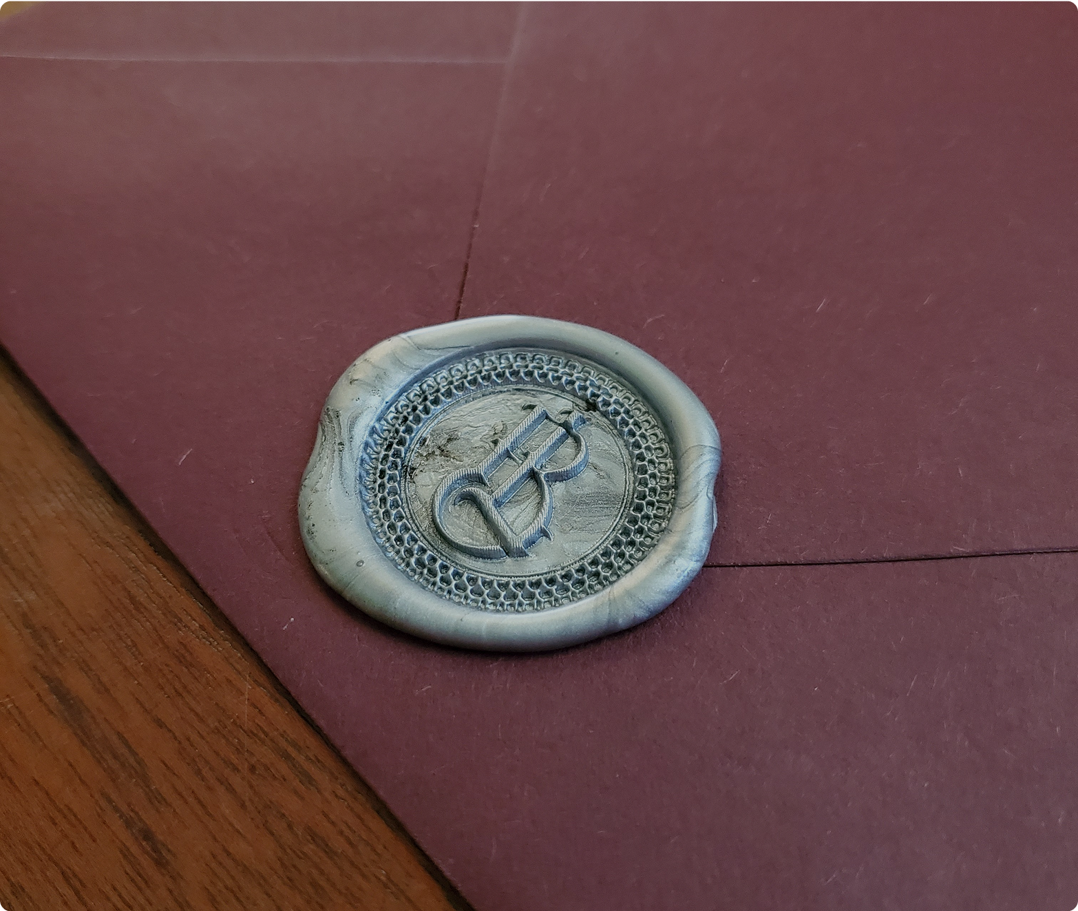 Burgundy envelope with decorative silver wax seal for romance letters