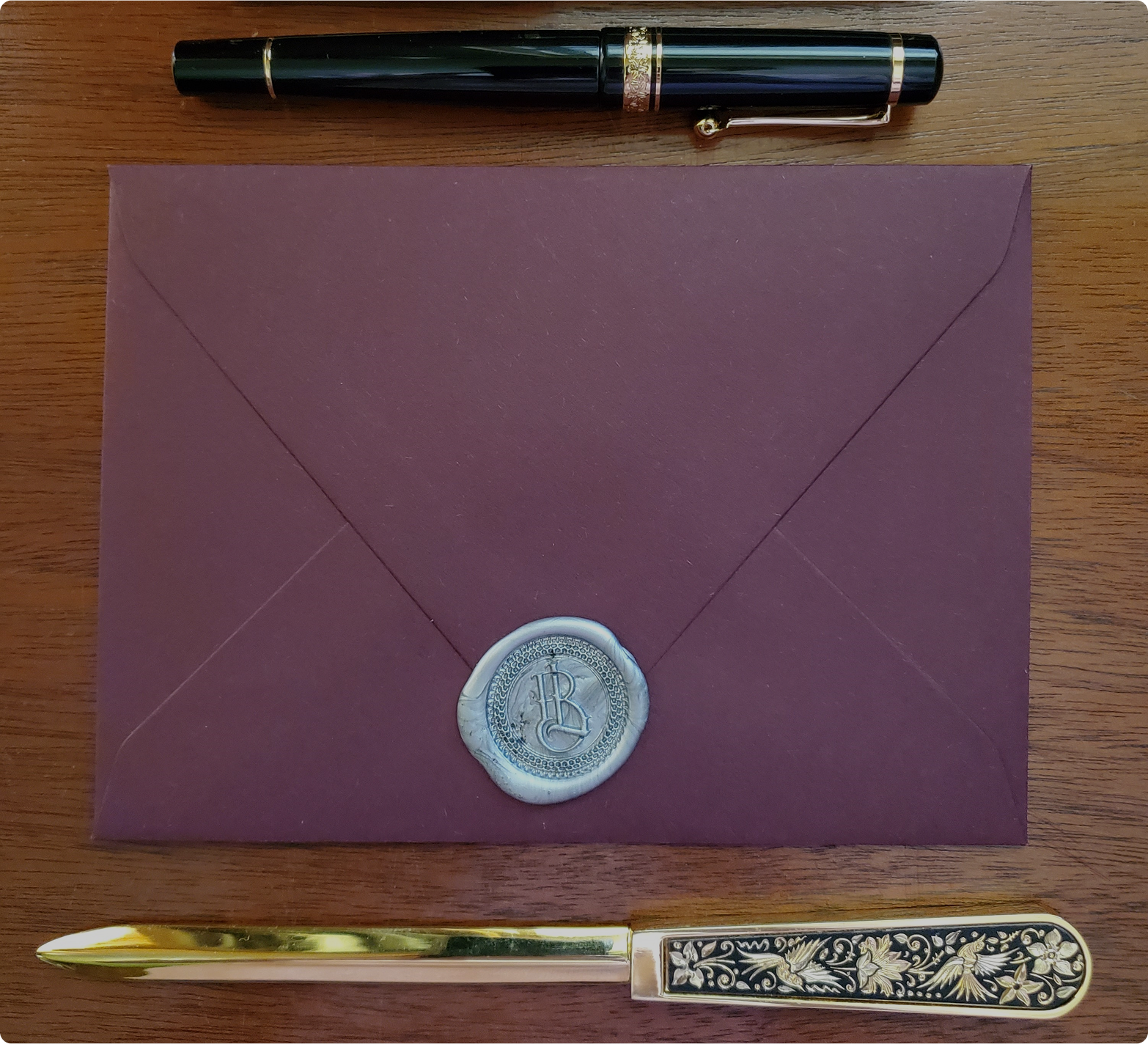 Burgundy envelope with decorative silver wax seal for romance letters